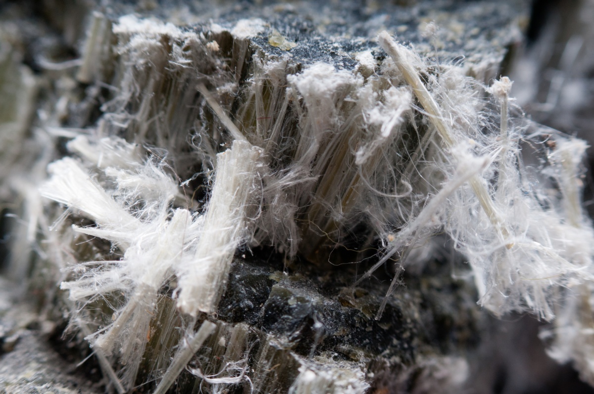 Fibres d'amiante blanches sur roche sombre, diagnostic amiante immobilier